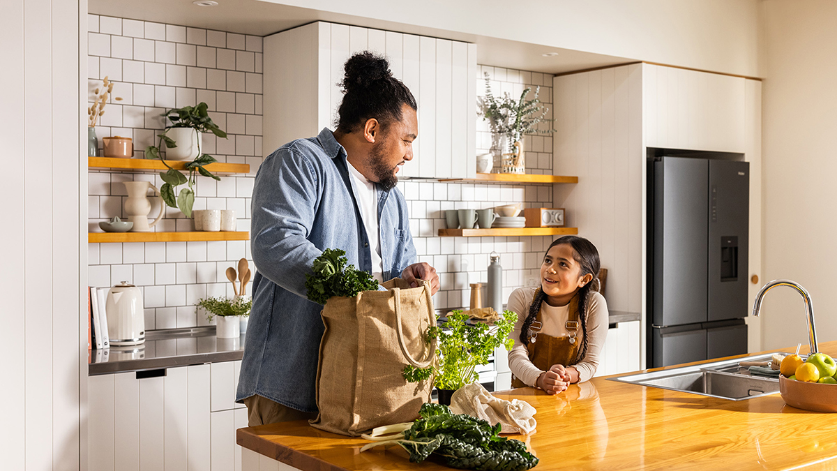 A father and daughter bringing fresh greens into the kitchen