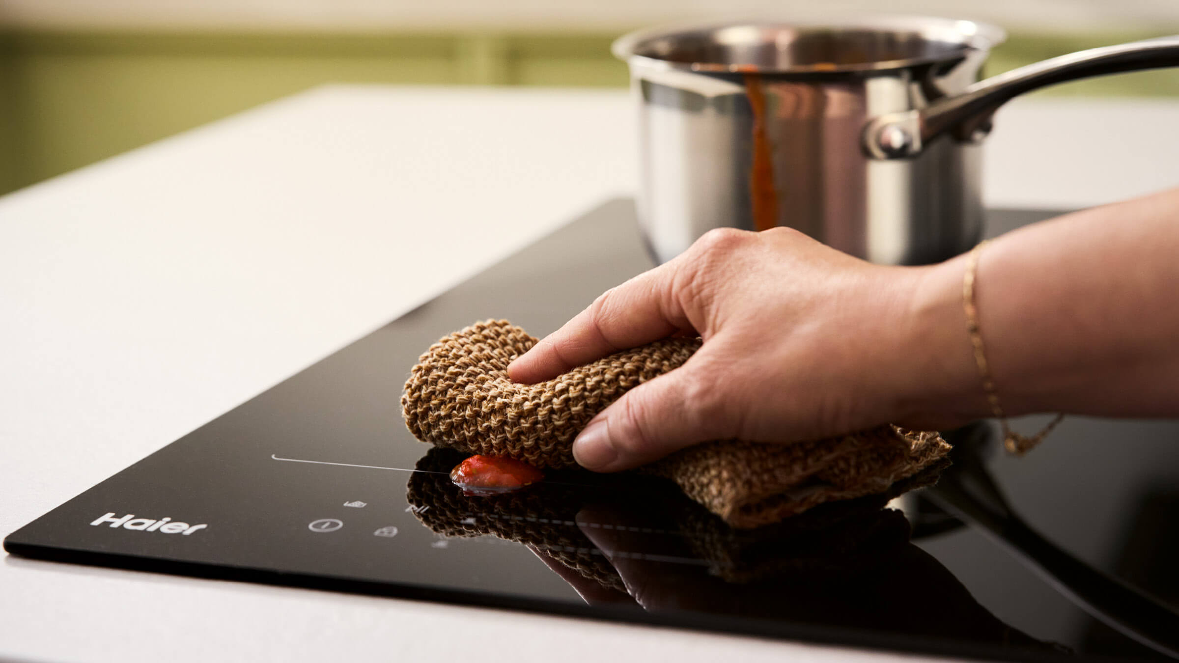 Hand wiping induction cooktop surface clean