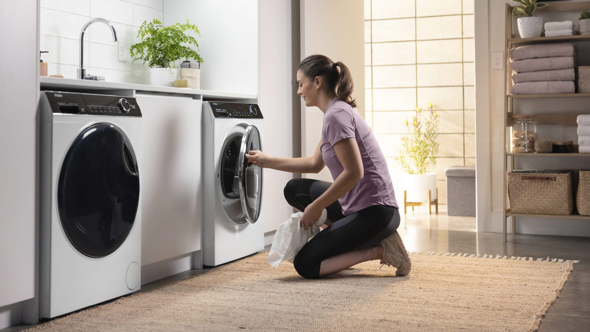 Woman using a Haier Heat Pump Dryer.