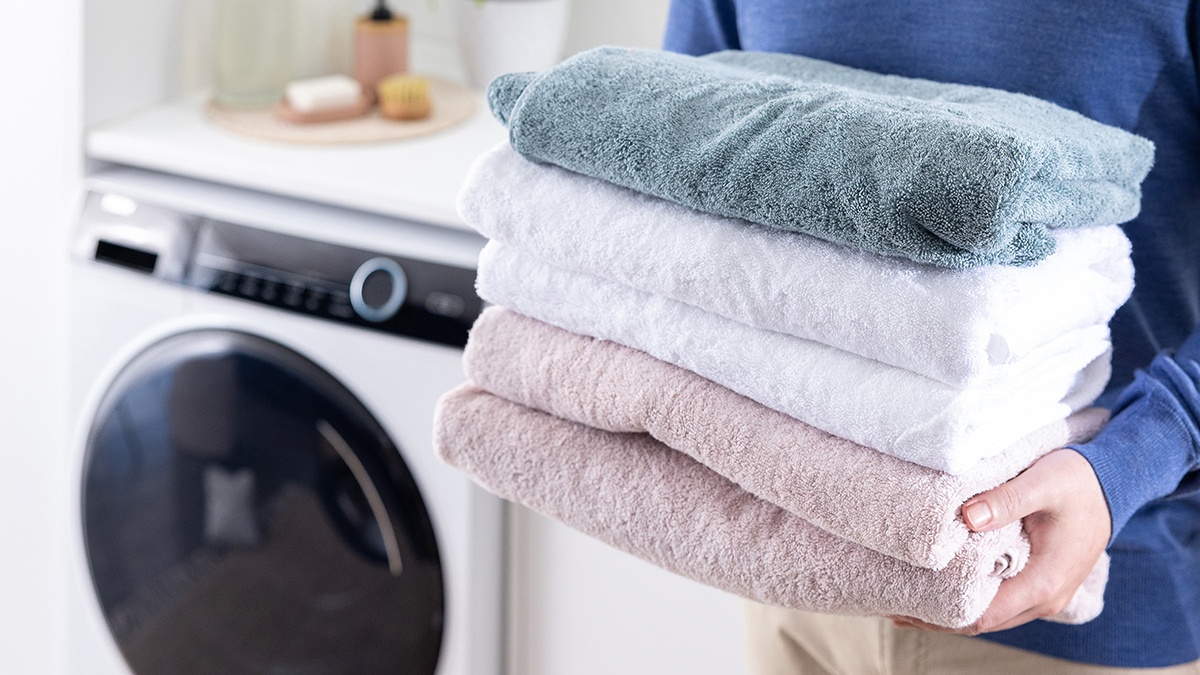 A pile of folded towels being carried